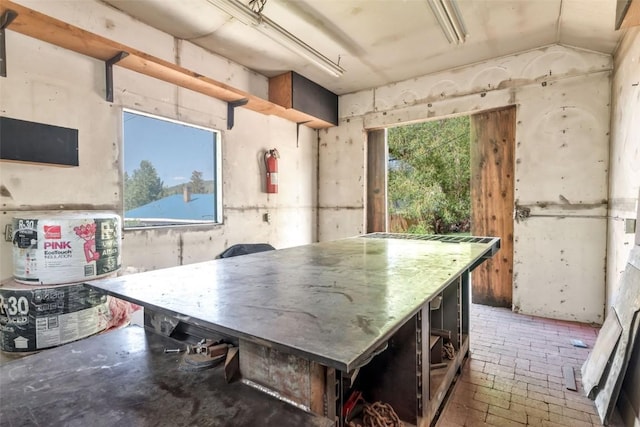 211 W Oak St, Oak Creek, CO 80467 - misc room with vaulted ceiling, brick patterned floors, and a workshop area