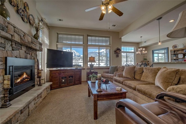 131 Allegra Ln Unit 131, Silverthorne, CO 80498 - living area featuring light carpet, ceiling fan, a stone fireplace, and a chandelier