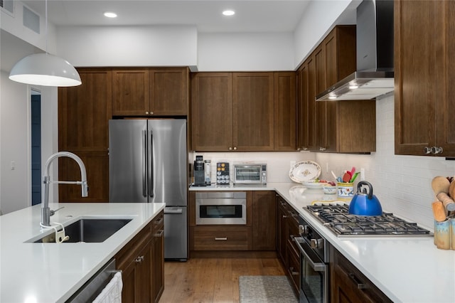 1460 Bangtail Way Unit 1B, Steamboat Springs, CO 80487 - kitchen with wall chimney range hood, appliances with stainless steel finishes, a sink, light countertops, and recessed lighting