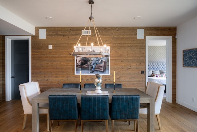 1460 Bangtail Way Unit 1B, Steamboat Springs, CO 80487 - dining room with wood walls, a chandelier, wood finished floors, and baseboards