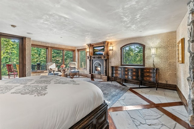 165 River Park Dr, Breckenridge, CO 80424 - bedroom featuring inlaid floor details, access to outside, marble finish flooring, and a warm lit fireplace