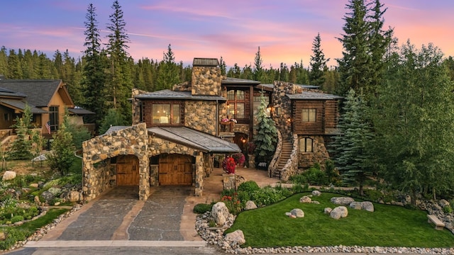 165 River Park Dr, Breckenridge, CO 80424 - view of front of house with a chimney, stone siding, stairway, driveway, and a front lawn