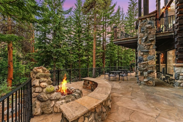 165 River Park Dr, Breckenridge, CO 80424 - patio terrace at dusk featuring an outdoor fire pit, a balcony, a patio, and outdoor dining area