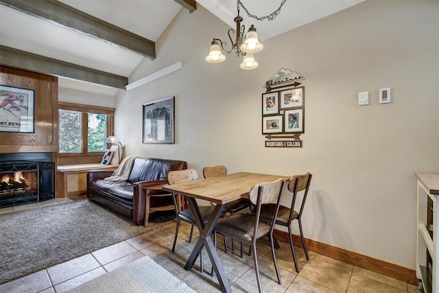 dining room with light tile patterned flooring, vaulted ceiling with beams, a large fireplace, baseboards, and a notable chandelier