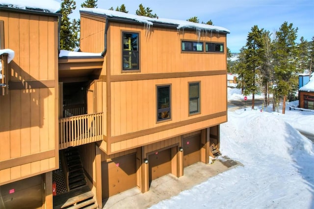 snow covered property featuring a garage