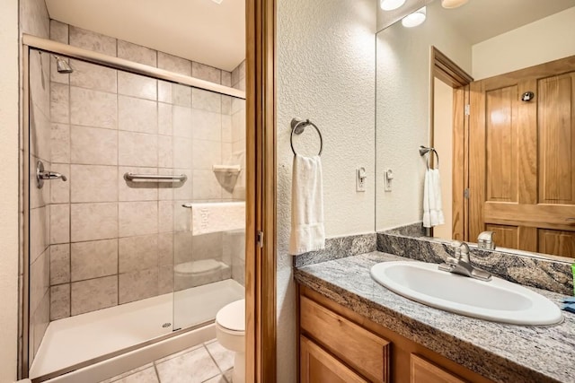 231 Creekside Dr Unit 102, Frisco, CO 80443 - bathroom featuring a stall shower, vanity, tile patterned floors, and a textured wall