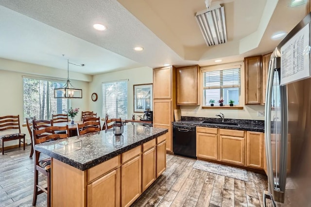 231 Creekside Dr Unit 102, Frisco, CO 80443 - kitchen with black dishwasher, freestanding refrigerator, light wood finished floors, a kitchen bar, and recessed lighting