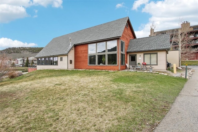 22320 US Highway 6 Unit 1762, Keystone, CO 80435 - back of house featuring a lawn, a sunroom, and roof with shingles