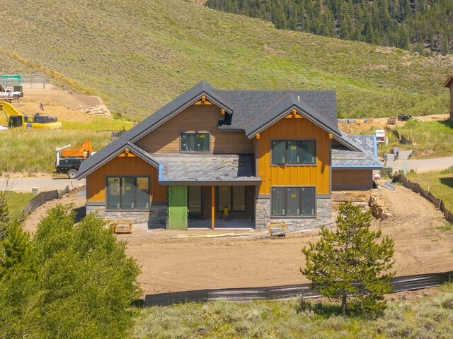 385 Lone Eagle Dr, Granby, CO 80446 - rear view of house with stone siding and a forest view