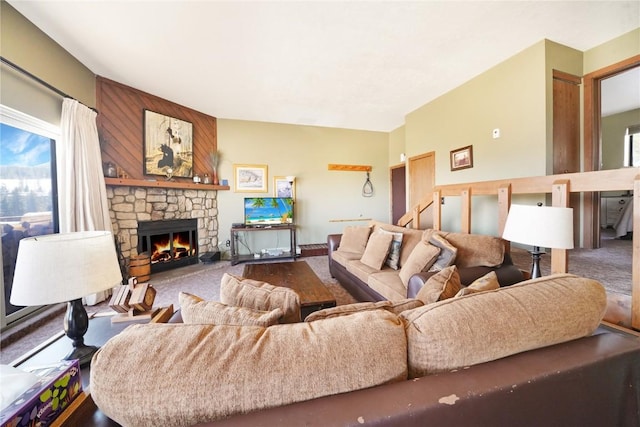 carpeted living room with a stone fireplace and plenty of natural light
