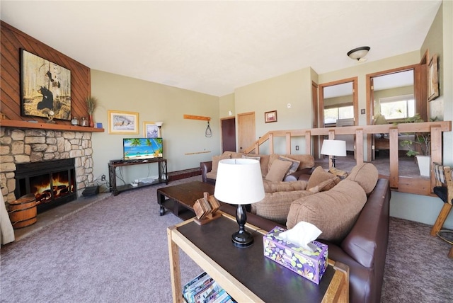 carpeted living room with a stone fireplace