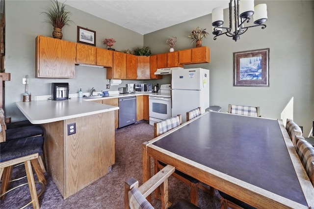 kitchen featuring a sink, white appliances, dark carpet, a peninsula, and a notable chandelier