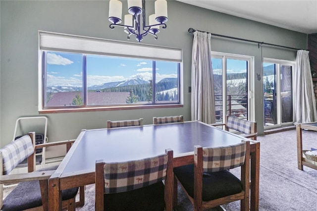 dining area featuring carpet floors, a notable chandelier, and a mountain view