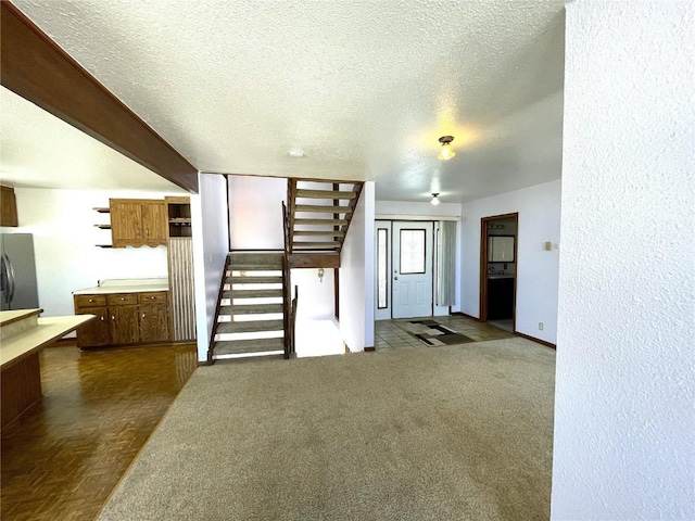 2584 High Creek Rd, Fairplay, CO 80440 - unfurnished living room featuring baseboards, a textured ceiling, and stairs