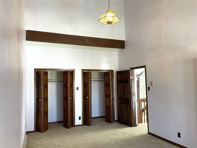 2584 High Creek Rd, Fairplay, CO 80440 - unfurnished bedroom with carpet floors, a towering ceiling, multiple closets, and baseboards