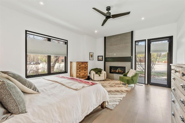 582 Laurel St, Steamboat Springs, CO 80487 - bedroom featuring access to outside, wood finished floors, recessed lighting, a large fireplace, and ceiling fan