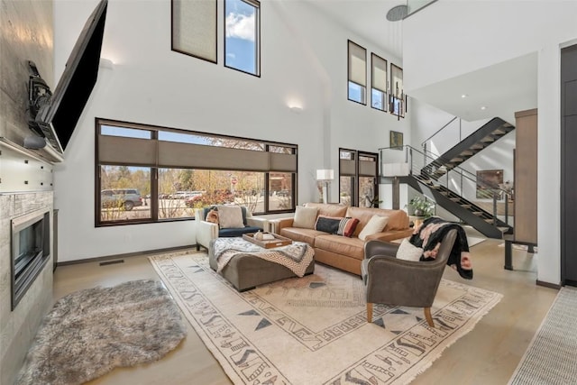 582 Laurel St, Steamboat Springs, CO 80487 - living room featuring a towering ceiling, stairway, a fireplace, wood finished floors, and baseboards