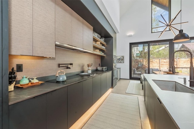 582 Laurel St, Steamboat Springs, CO 80487 - kitchen featuring a sink, oven, black electric stovetop, a high ceiling, and modern cabinets