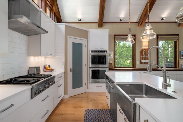 1511 Harwig Cir, Steamboat Springs, CO 80487 - kitchen with range hood, a sink, white cabinets, stainless steel appliances, and light wood-style flooring