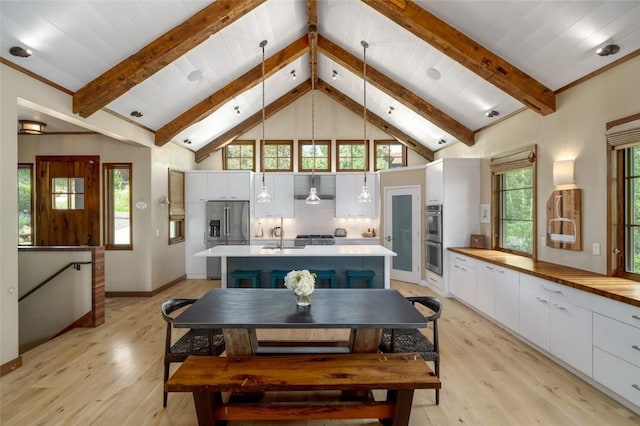 1511 Harwig Cir, Steamboat Springs, CO 80487 - dining area with beamed ceiling, high vaulted ceiling, baseboards, and light wood-style floors