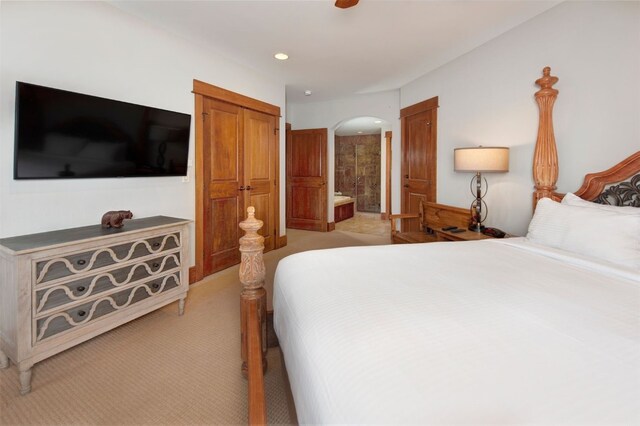 280 Trailhead Dr Unit 3037, Keystone, CO 80435 - bedroom featuring arched walkways, ceiling fan, light carpet, and connected bathroom