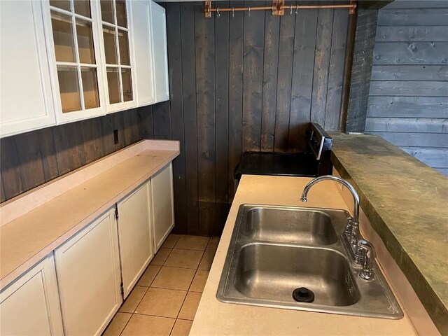 810 Broad St, Steamboat Springs, CO 80487 - kitchen featuring a sink, wood walls, white cabinets, range with electric cooktop, and light tile patterned flooring