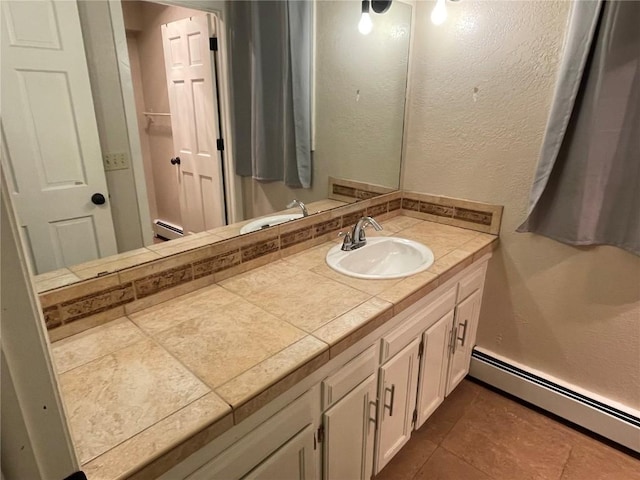 810 Broad St, Steamboat Springs, CO 80487 - bathroom with a baseboard radiator, vanity, a textured wall, and tile patterned floors