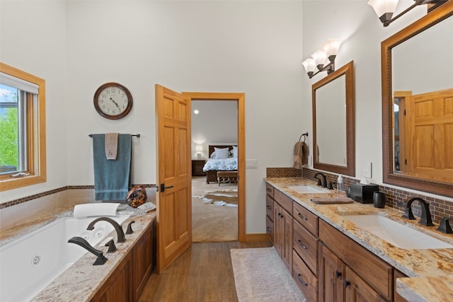 736 Wild Rose Rd, Silverthorne, CO 80498 - ensuite bathroom with a high ceiling, double vanity, wood finished floors, a whirlpool tub, and tasteful backsplash