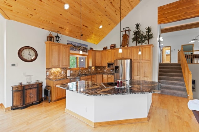736 Wild Rose Rd, Silverthorne, CO 80498 - kitchen with stainless steel appliances, light wood-type flooring, decorative backsplash, a center island, and dark stone counters