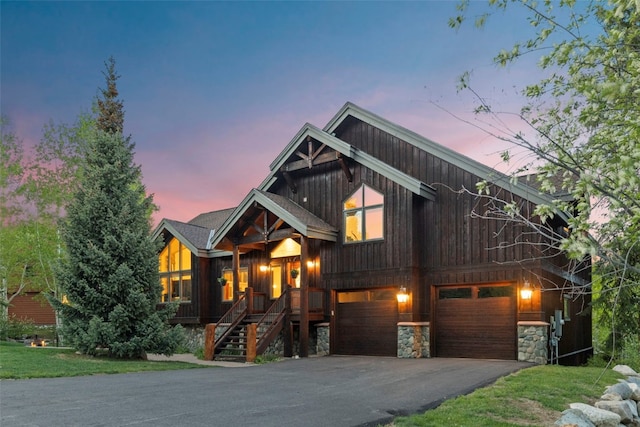 736 Wild Rose Rd, Silverthorne, CO 80498 - chalet / cabin featuring driveway, a garage, a porch, stone siding, and stairway