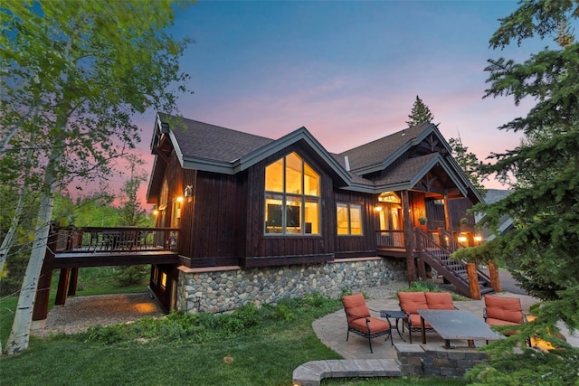 736 Wild Rose Rd, Silverthorne, CO 80498 - back of house at dusk with a patio area, stairs, a deck, an outdoor living space, and roof with shingles