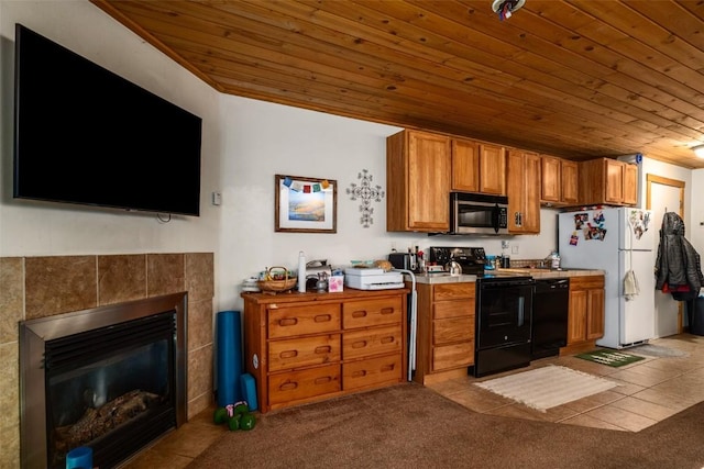 2883 Burgess Creek Rd Unit 101, Steamboat Springs, CO 80487 - kitchen featuring carpet, brown cabinets, wood ceiling, a tile fireplace, and black appliances