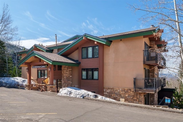 2883 Burgess Creek Rd Unit 101, Steamboat Springs, CO 80487 - rustic home with stucco siding, stone siding, and a balcony
