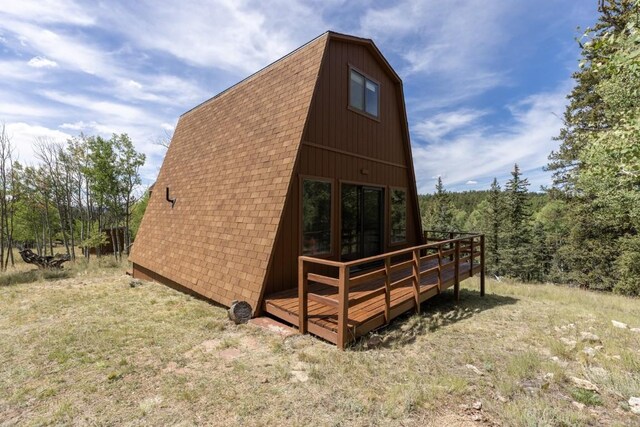 33 Sugar Loaf Ln, Jefferson, CO 80456 - view of property exterior with roof with shingles, a gambrel roof, a view of trees, and a deck