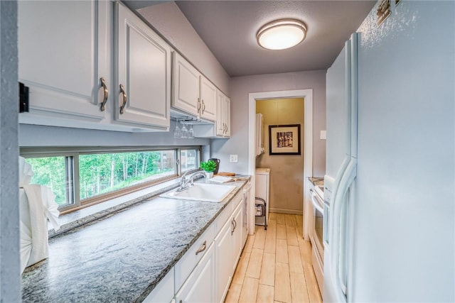 2510 Ryan Gulch Rd Unit 2512, Silverthorne, CO 80498 - kitchen featuring freestanding refrigerator, stove, white cabinets, light stone countertops, and light wood-type flooring