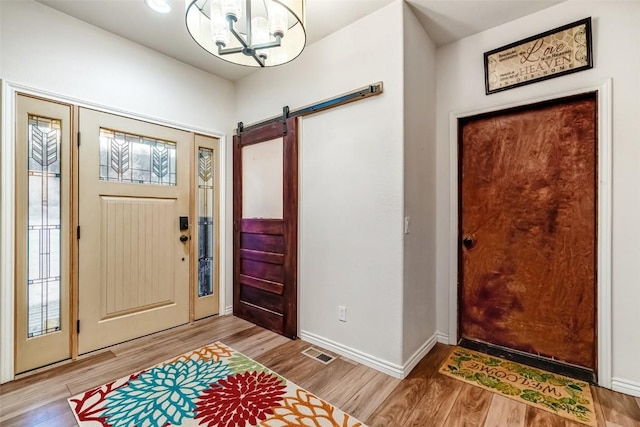 53 Anhinga Rd, Como, CO 80432 - entryway with a barn door, light wood-type flooring, visible vents, and a notable chandelier