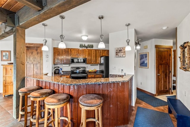 2700 Village Dr Unit C107, Steamboat Springs, CO 80487 - kitchen featuring black appliances, a peninsula, a kitchen bar, dark stone counters, and light tile patterned floors