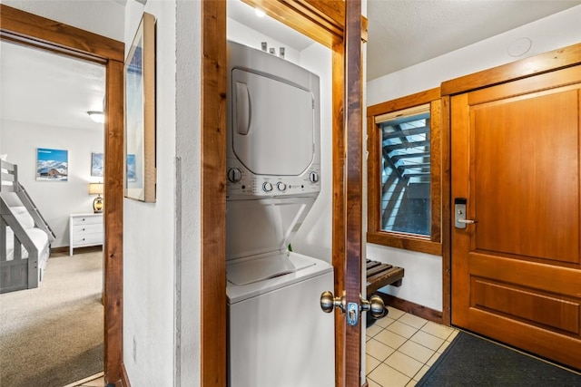 2700 Village Dr Unit C107, Steamboat Springs, CO 80487 - washroom with estacked washer and dryer and tile patterned floors