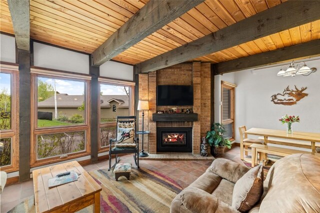 2700 Village Dr Unit C107, Steamboat Springs, CO 80487 - tiled living room with a brick fireplace, a chandelier, and wood ceiling with exposed beams