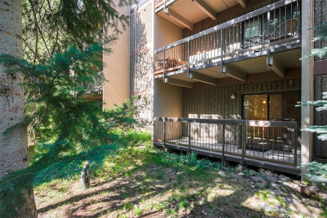 back of property with stucco siding and a balcony