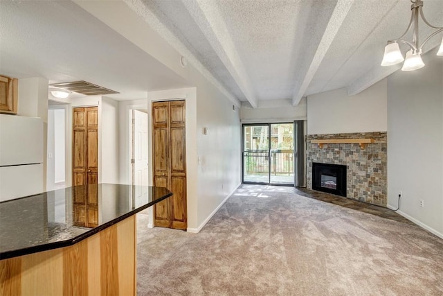 kitchen featuring light colored carpet, visible vents, baseboards, and freestanding refrigerator