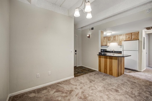 kitchen featuring freestanding refrigerator, visible vents, and light carpet