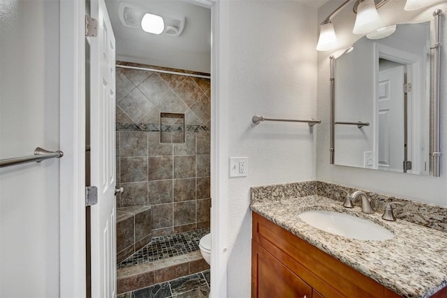 full bathroom featuring toilet, vanity, and a stall shower