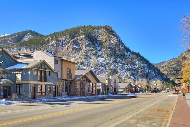 view of road featuring a mountain view, curbs, and sidewalks