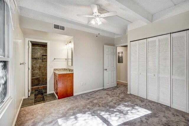 unfurnished bedroom featuring a closet, carpet, visible vents, electric panel, and beamed ceiling