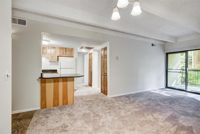 unfurnished living room with light carpet, a textured ceiling, baseboards, and visible vents