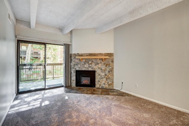 unfurnished living room with a textured ceiling, a fireplace, beam ceiling, and carpet floors
