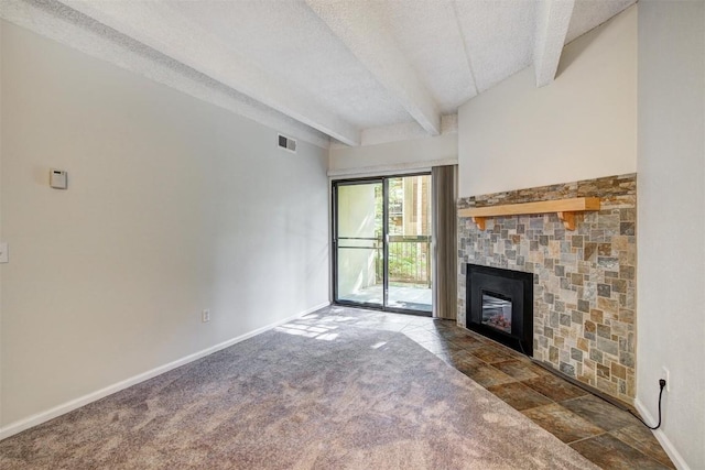 unfurnished living room featuring beam ceiling, a textured ceiling, visible vents, a fireplace, and baseboards