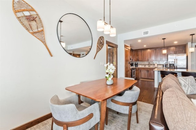dining area with baseboards, wood finished floors, visible vents, and recessed lighting