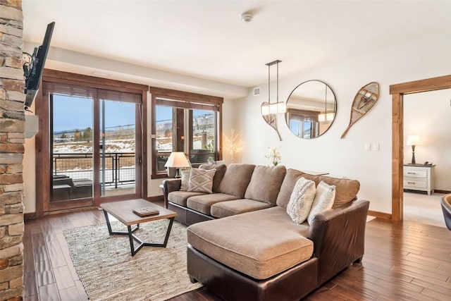 living area with hardwood / wood-style floors, baseboards, and visible vents